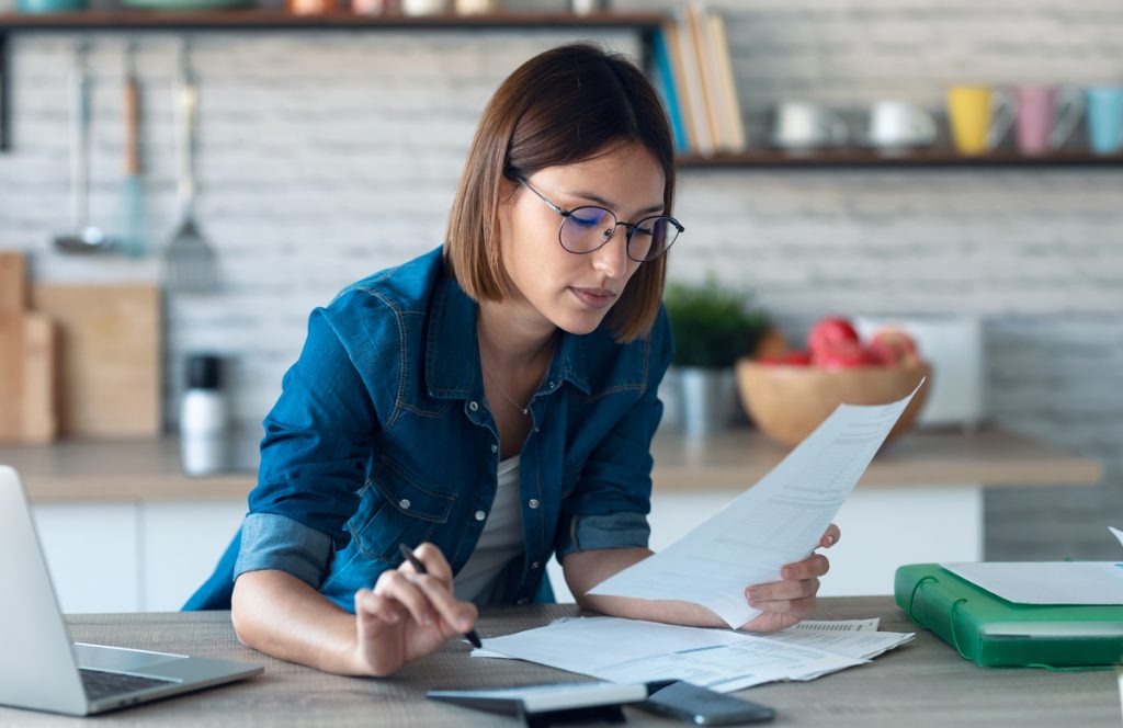 Orange County homeowner in her kitchen reviewing information on energy-efficient HVAC system upgrades, exploring cost-saving options for her home.