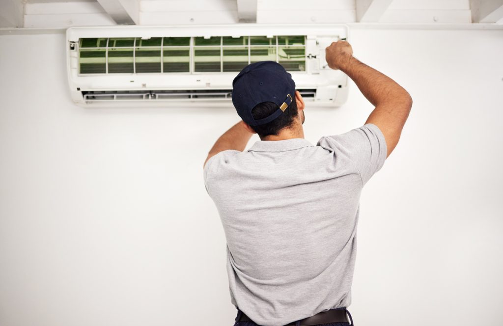 Skilled HVAC technician working on an HVAC system, part of the effort to improve indoor air quality in California homes.